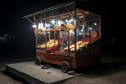 An Afghan vendor selling bread waits for customers by the roadside in Kabul