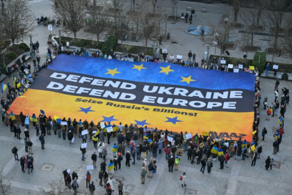 Demonstrators display a giant banner in the colours of the Ukrainian flag in Brussels on the eve of a special EU summit
