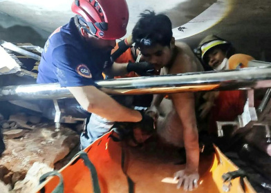 A joint team of Myanmar and Turkish rescuers pull a man alive from the rubble of a hotel in the capital Naypyidaw, five days after a major earthquake