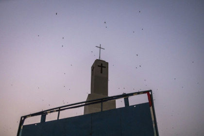 Bats fly over a church tower in Jos, capital of the religiously mixed Plateau state, Nigeria