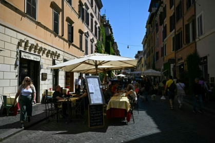 In the lively via Borgo Pio in the shadow of the Vatican, tourists pack into typical Roman restaurants and tacky souvenir shops - Gabriel BOUYS