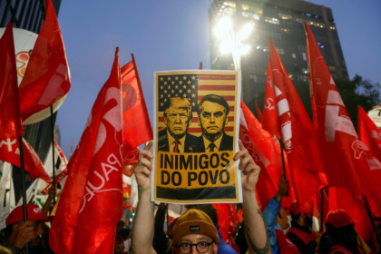 A poster declaring US President Donald Trump and former Brazilian President Jair Bolsonaro 'Enemies of the people' at a demonstration in Sao Paulo - Miguel SCHINCARIOL (AFP)