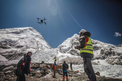 A man operates a heavy-lift drone to clear trash dumped at the Everest Base Camp - - (AFP)