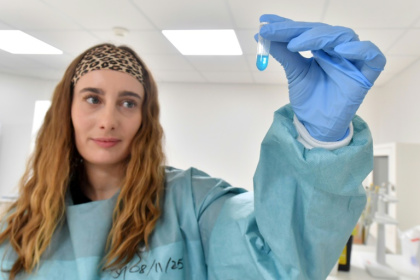 A scientist in the French city of Orleans holds up a test tube containing messenger RNA - JEAN-FRANCOIS MONIER (AFP)