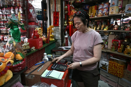Thitinan Suntisubpool, co-owner of a shop in Bangkok's Chinatown, said she loves how durable her big calculator is - Lillian SUWANRUMPHA (AFP)