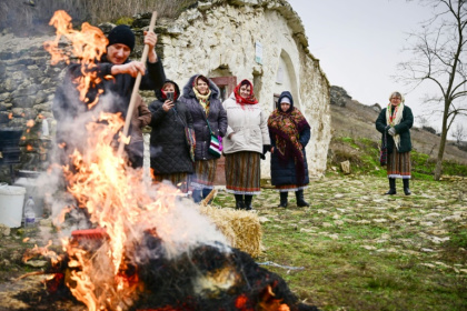 Local women watch the pig being roasted for the Christmas celebration in Rogojeni - Daniel MIHAILESCU (AFP)