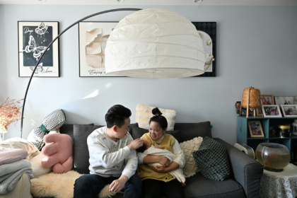 Zhang Xiaofei, 32 ans, et son époux Zhu Yunfei, 36 ans, avec leur fille de trois semaines dans leur appartement de Langfang, en périphérie de Pékin, le 6 mars 2026.jpg