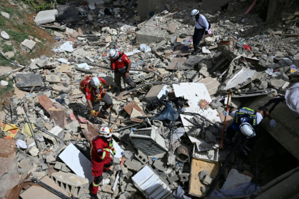 Costa Rican rescuers search through the rubble of a collapsed building in Catia La Mar, La Guaira state - Juan BARRETO (AFP)