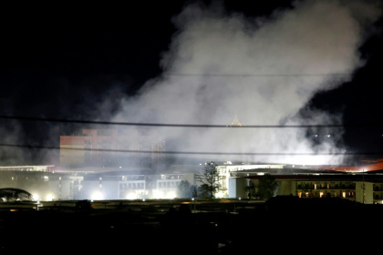 Smoke rises over buildings following an explosion in the KK Park compound in eastern Myanmar, as pictured from Mae Sot District in Thailand's Tak Province on October 24, 2025 - Sarot Meksophawannakul (AFP)